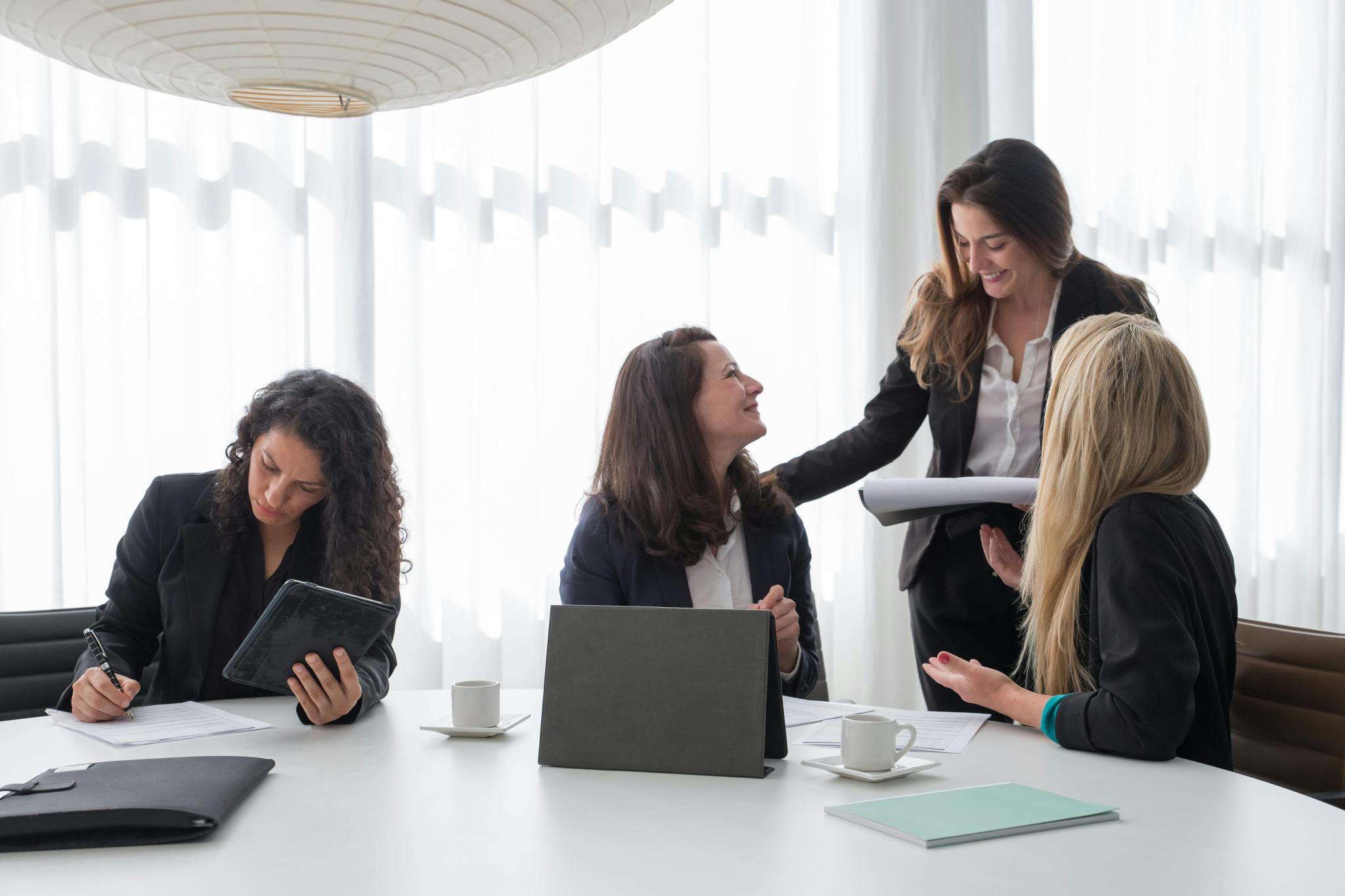 Women sitting at boardroom table talking