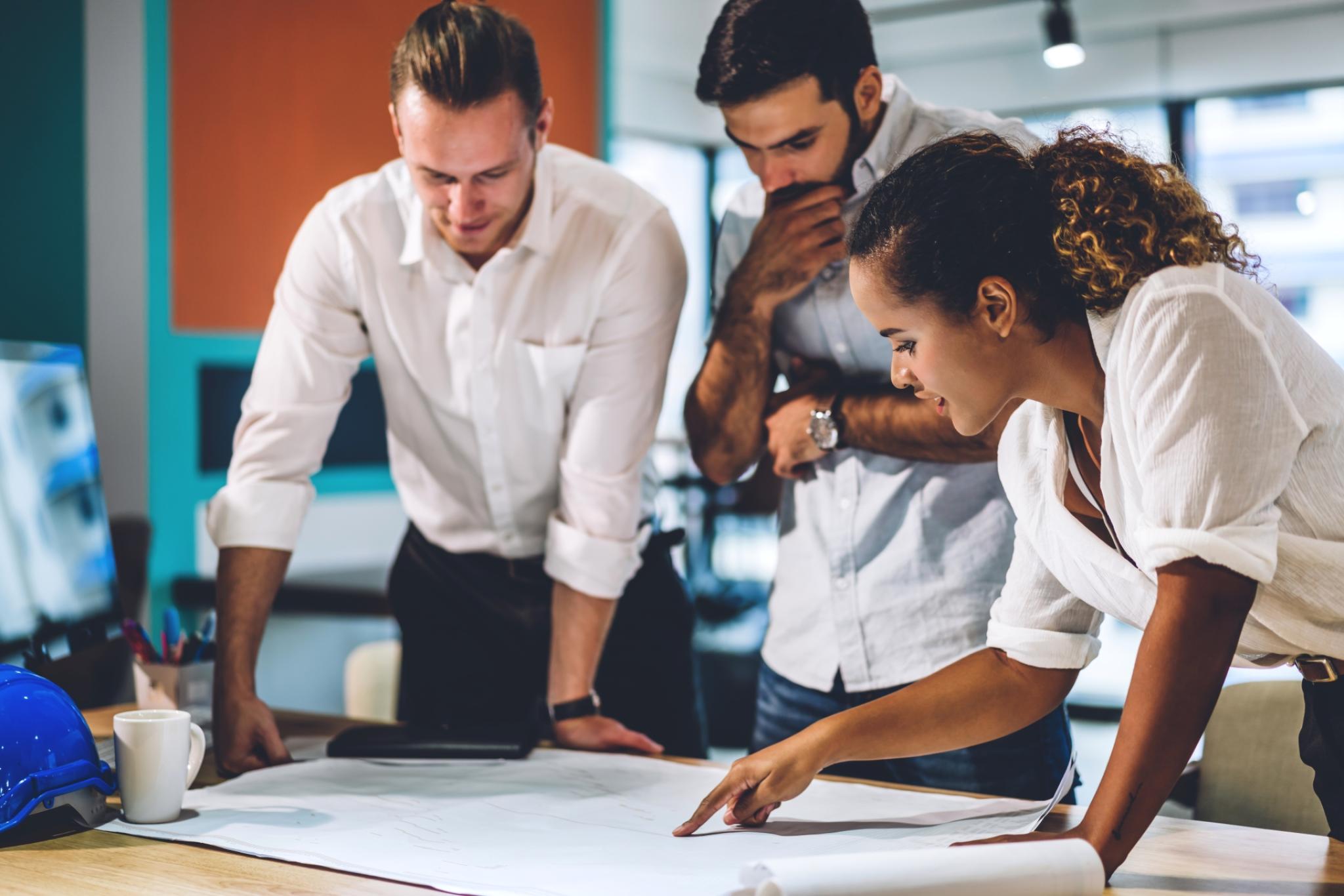 Image of professionals around a table. Image: Adobe stock