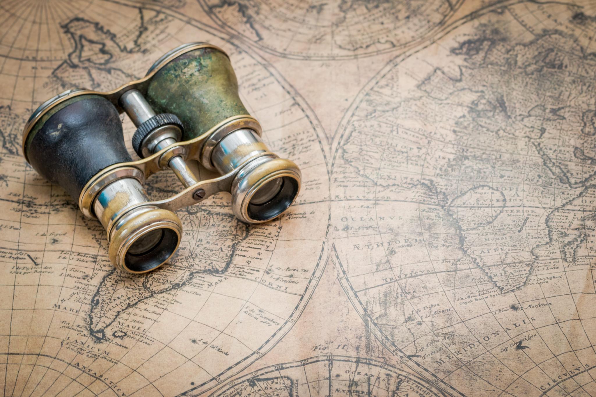 Pair of old binoculars on an antique map