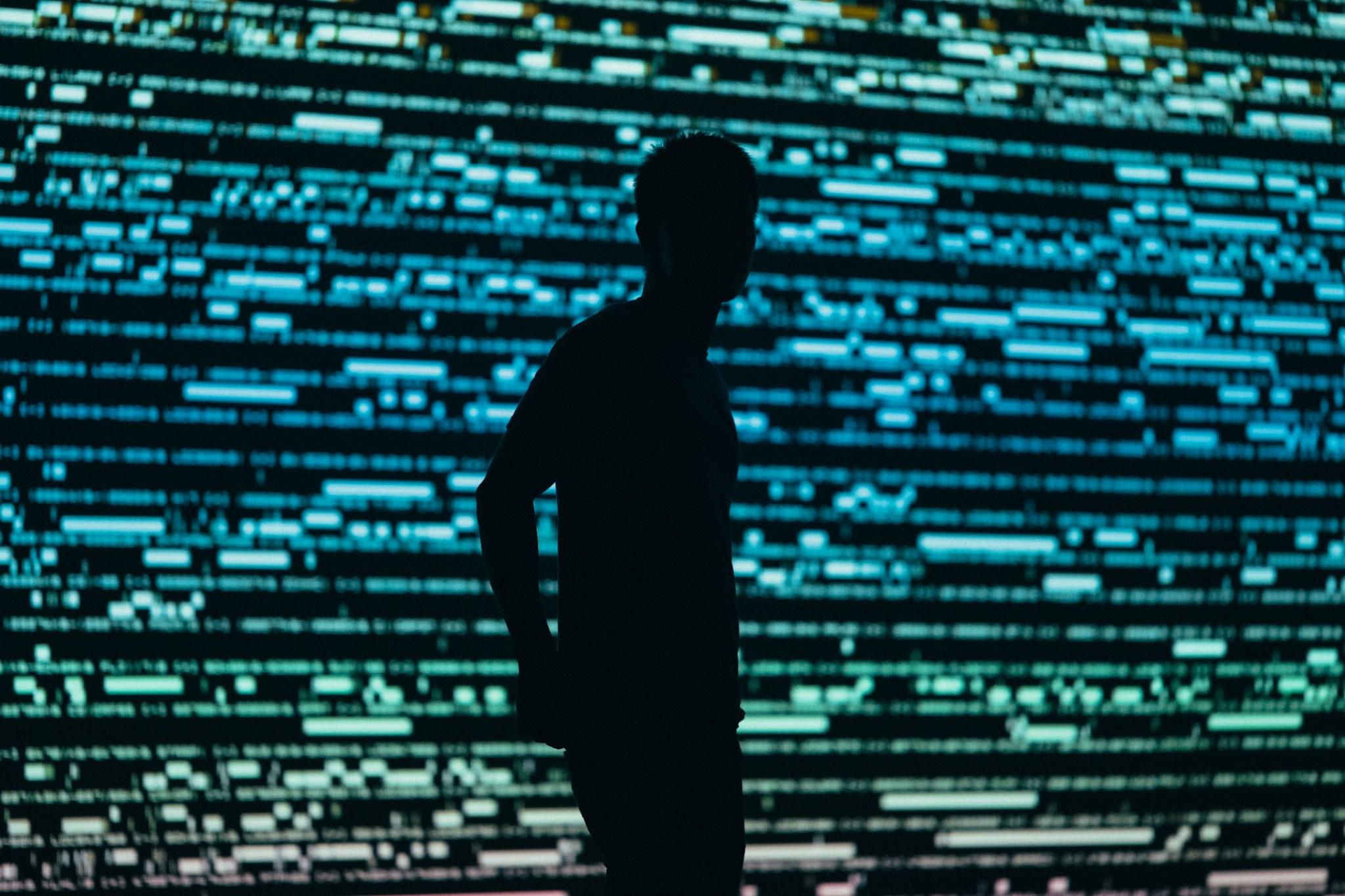 Silhouette of a man in front of a screen