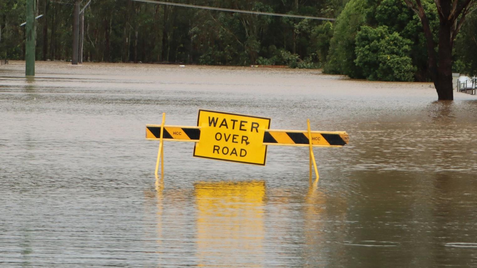 Flooded road with a caution sign