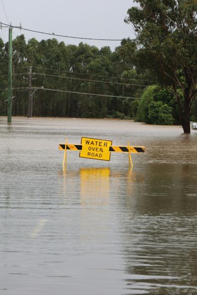 Flooded road with a caution sign